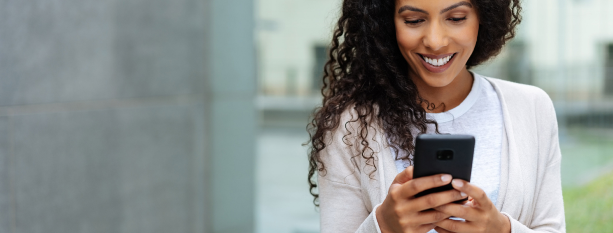women smiling looking at her phone